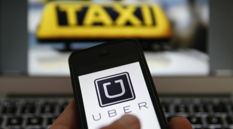 An illustration picture shows the logo of car-sharing service app Uber on a smartphone next to the picture of an official German taxi sign in Frankfurt, September 15, 2014. A Frankfurt high court will hold a hearing on a recent lawsuit brought against Uberpop by Taxi Deutschland on Tuesday. San Francisco-based Uber, which allows users to summon taxi-like services on their smartphones, offers two main services, Uber, its classic low-cost, limousine pick-up service, and Uberpop, a newer ride-sharing service, which connects private drivers to passengers - an established practice in Germany that nonetheless operates in a legal grey area of rules governing commercial transportation. The company has faced regulatory scrutiny and court injunctions from its early days, even as it has expanded rapidly into roughly 150 cities around the world. REUTERS/Kai Pfaffenbach (GERMANY - Tags: BUSINESS EMPLOYMENT CRIME LAW TRANSPORT)