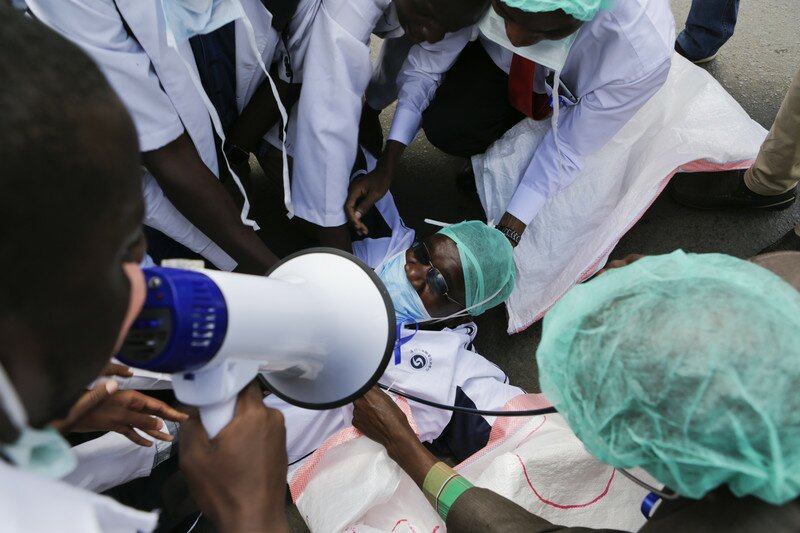 epa05661041 Kenyan health workers play as conducting a CPR (Cardiopulmonary Resuscitation) during a protest in Nairobi, Kenya, 05 December 2016. Thousands of health workers took to the streets in efforts to push the government to implement a Collective Bargaining Agreement (CBA) they signed in June 2013 to improve pay and conditions of work. Protesters demand a review of job groups, promotions, deployment and transfer of medical officers, as well as pay rise. According to local media, the country wide strike by nearly 5,000 doctors, nurses, pharmacists, dentists and interns is likely to affect at over 2,700 public health facilities including Kenyatta National Hospital and Moi Teaching and Referral Hospital in Eldoret, where most Kenyans seek emergency medical care. EPA/DANIEL IRUNGU