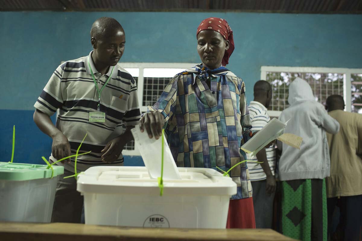 IEBC official shows a woman how to cast her vote during the Kenyan general elections in northern Kenya