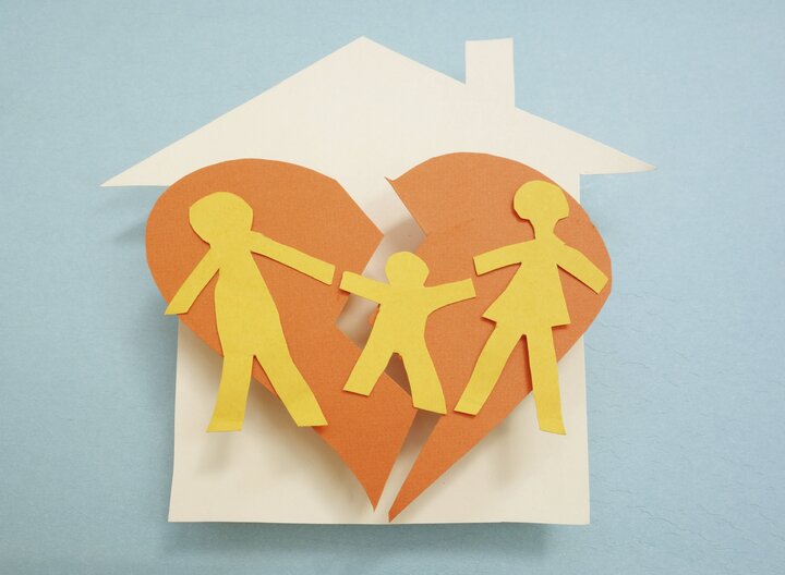 Paper family over torn heart, on house - divorce concept